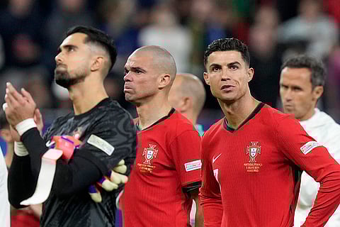 Diogo Costa, Pepe and Cristiano Ronaldo react after losing a quarter final match against France